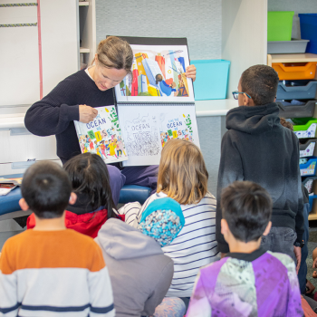 Role model pointing to a picture in front of children